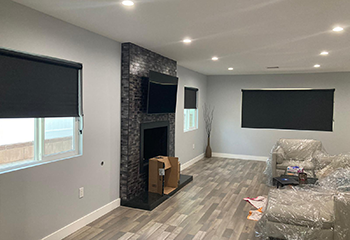 Modern living room with fireplace and blackout roller shades in Los Altos